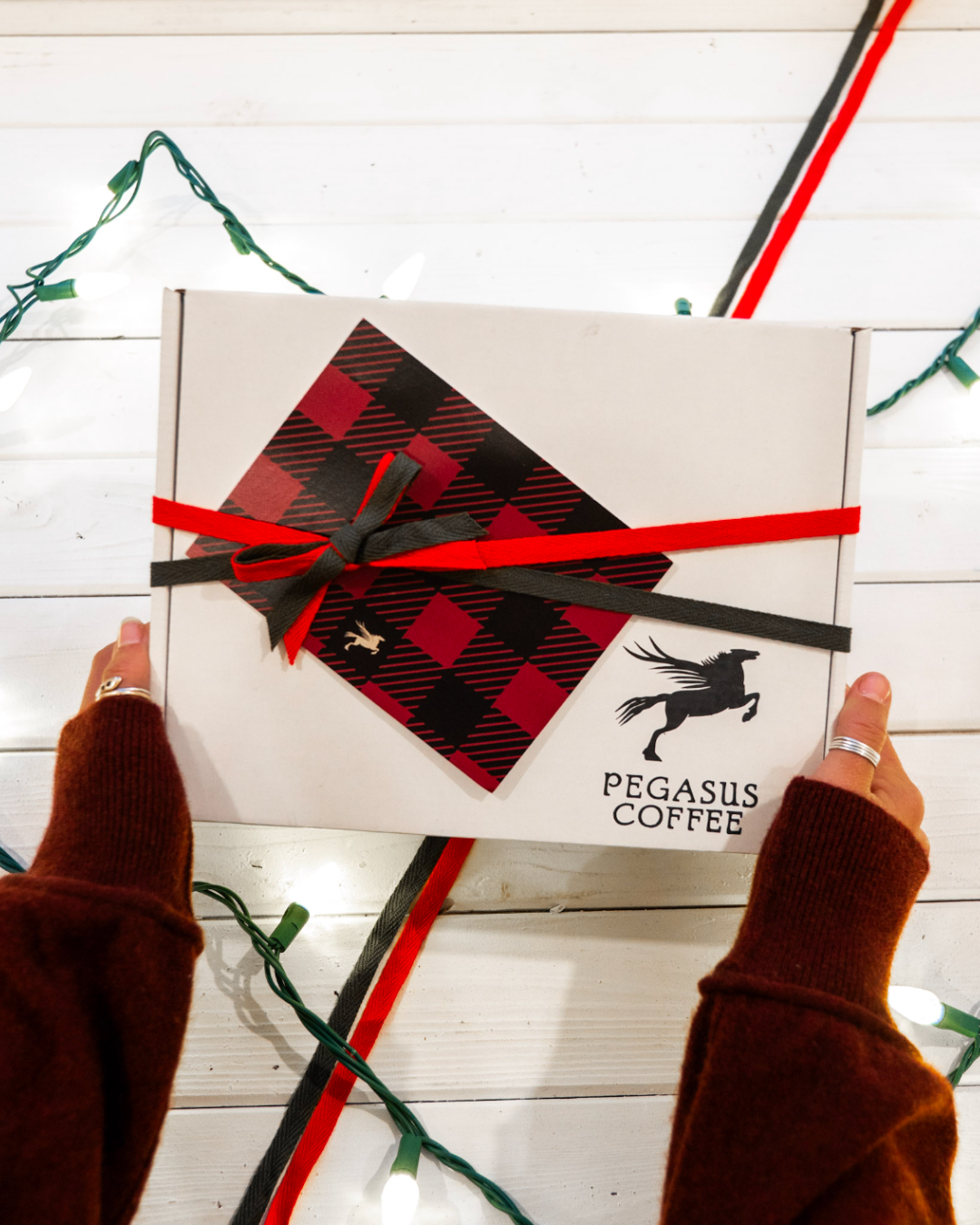 A pegasus coffee gift box wrapped in ribbon with a handwritten note