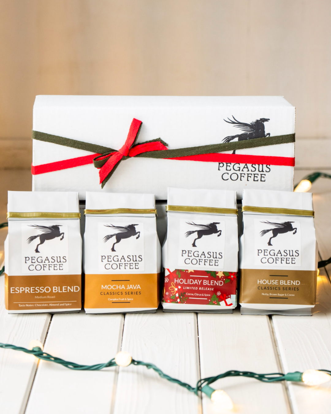Pegasus Coffee Sampler Set, Espresso Blend, Mocha Java, Holiday Blend, and House Blend in front of gift box